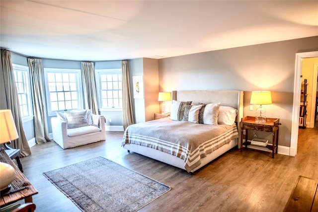 bedroom with baseboards and wood finished floors