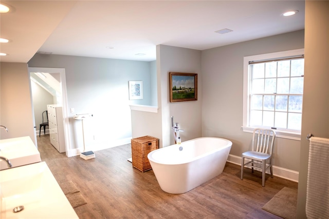 bathroom with vanity, a washtub, and hardwood / wood-style flooring