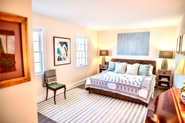 bedroom with hardwood / wood-style flooring and multiple windows