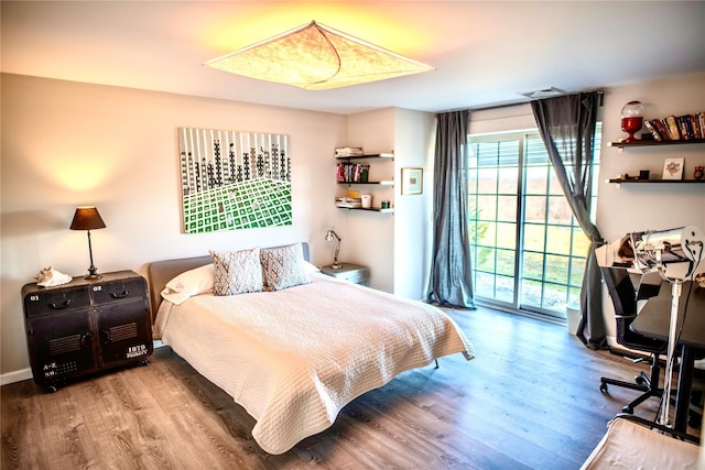 bedroom with wood-type flooring and access to outside