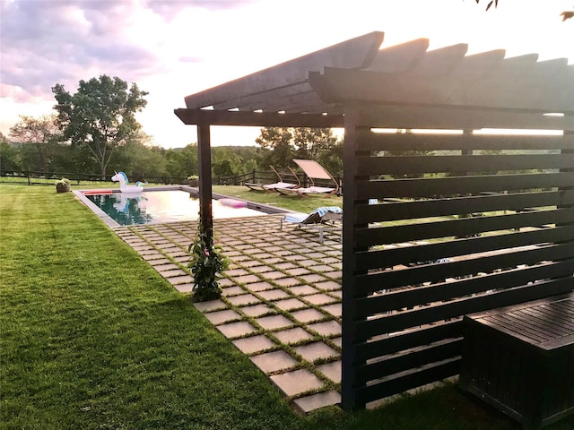 yard at dusk featuring a pergola and a patio