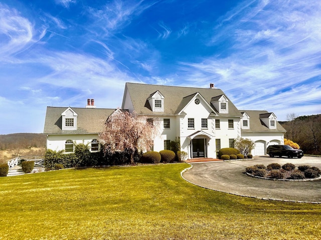 view of front of house featuring a garage, concrete driveway, and a front lawn