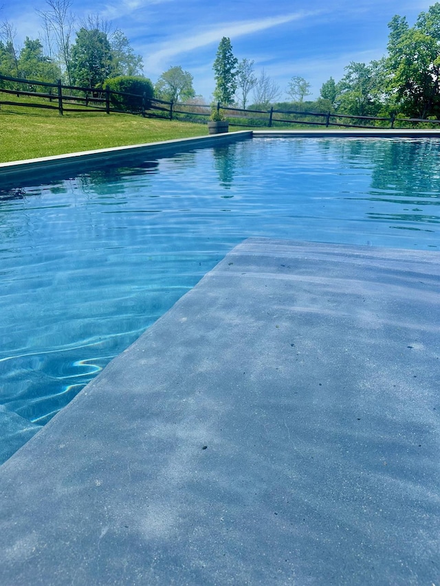 view of pool with a pool, fence, and a yard