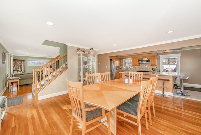 dining room featuring ornamental molding and light wood-type flooring