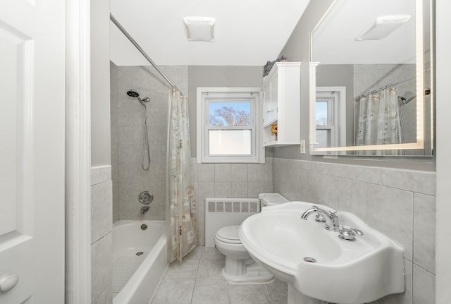 full bathroom with tile patterned floors, sink, tile walls, radiator, and shower / bath combo with shower curtain