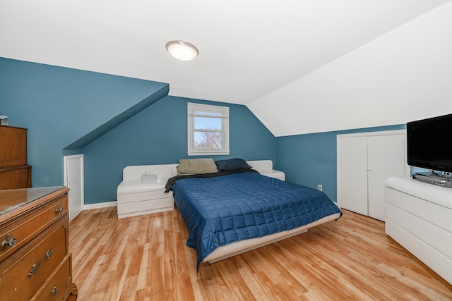 bedroom with vaulted ceiling and light hardwood / wood-style floors