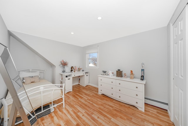 bedroom featuring light hardwood / wood-style floors, a closet, and baseboard heating