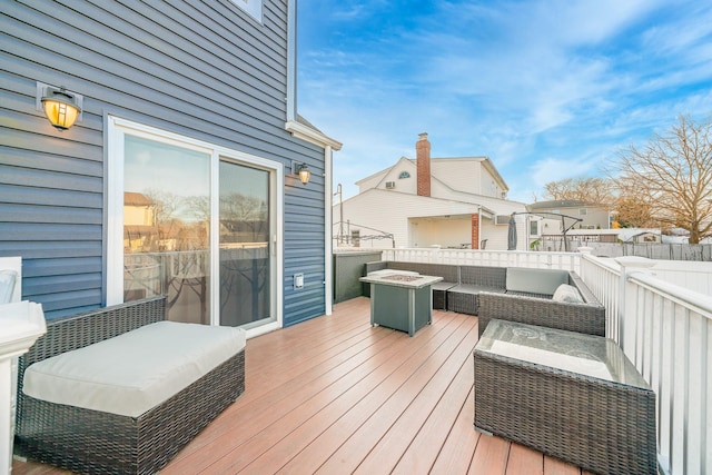 wooden deck featuring an outdoor living space with a fire pit