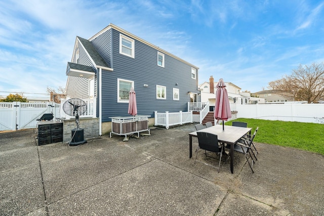 back of property with a yard and a patio area