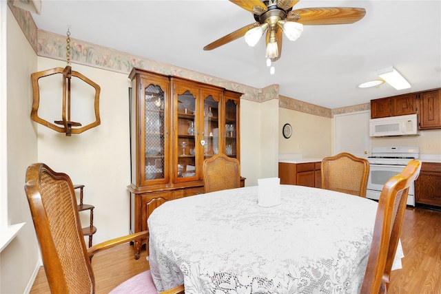 dining area featuring ceiling fan and light wood-type flooring