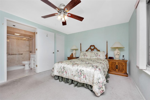 bedroom featuring ensuite bathroom, ceiling fan, and light colored carpet