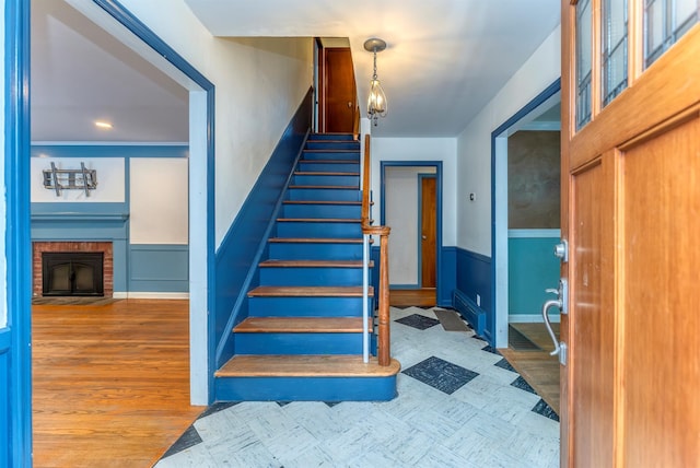 stairs featuring wood-type flooring and a fireplace