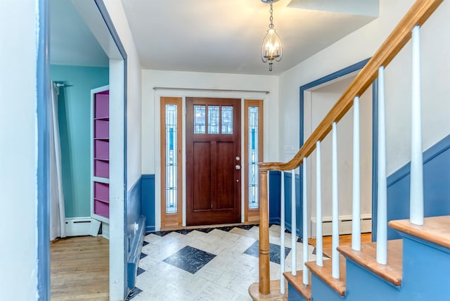 foyer entrance with a baseboard heating unit and light hardwood / wood-style flooring