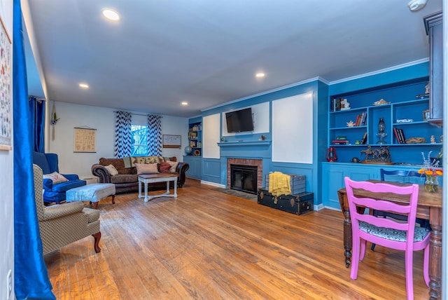 living room featuring hardwood / wood-style flooring and a brick fireplace