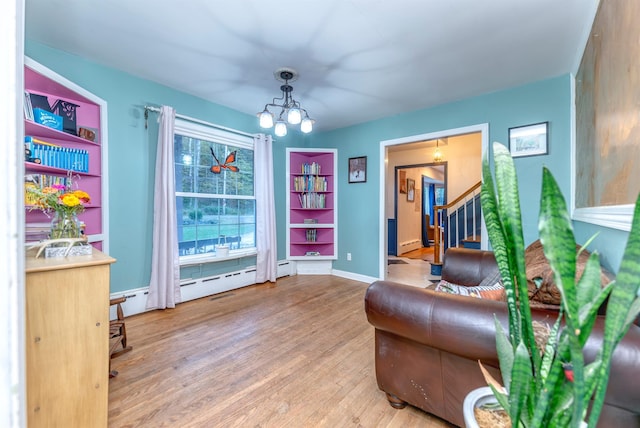 living area featuring wood-type flooring, an inviting chandelier, and a baseboard radiator