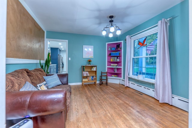 living area featuring hardwood / wood-style flooring, an inviting chandelier, and baseboard heating