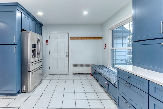 kitchen with stainless steel fridge with ice dispenser, radiator, and light tile patterned flooring