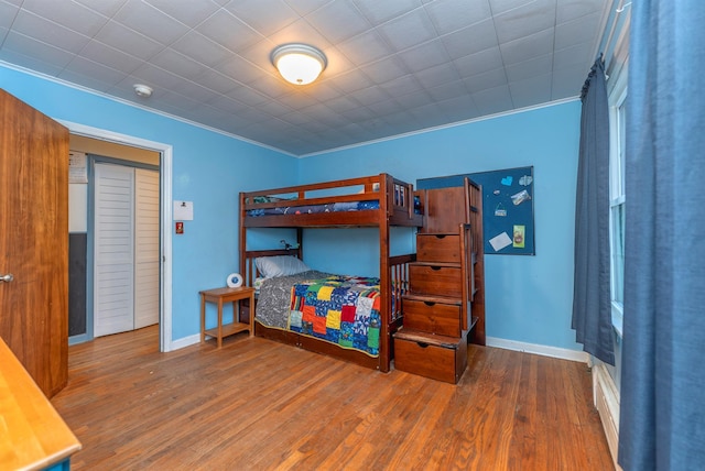 bedroom featuring hardwood / wood-style flooring and crown molding