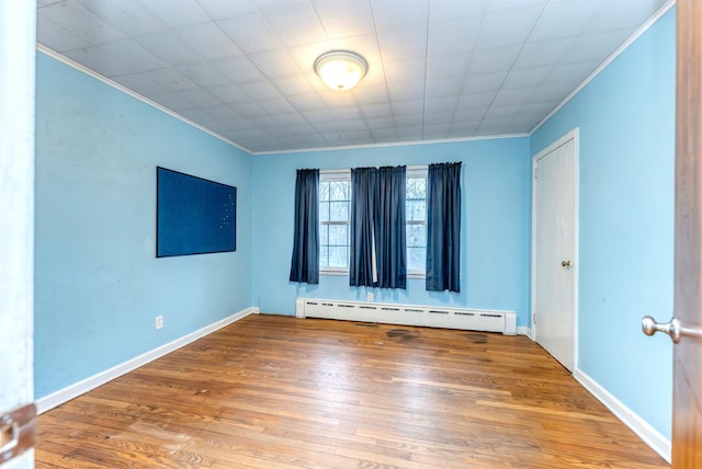 unfurnished room featuring ornamental molding, hardwood / wood-style floors, and baseboard heating