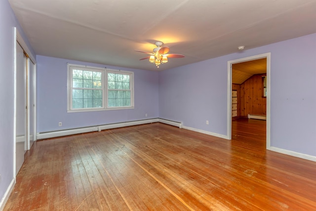 unfurnished bedroom featuring vaulted ceiling, a baseboard radiator, and light hardwood / wood-style floors