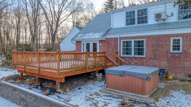 snow covered deck with a hot tub