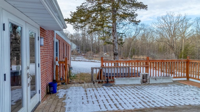 snow covered deck with french doors