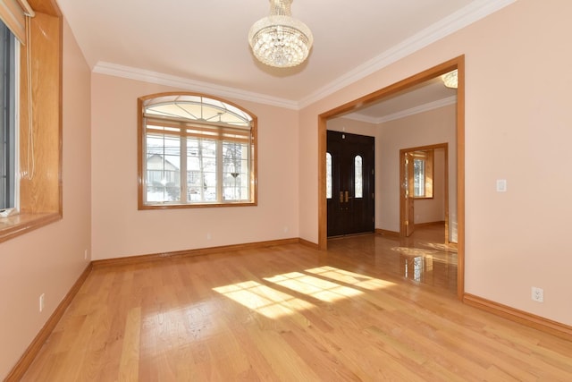 empty room with an inviting chandelier, ornamental molding, and light wood-type flooring