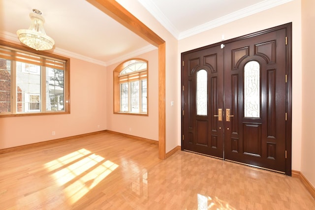 entryway with a notable chandelier, crown molding, and light hardwood / wood-style flooring