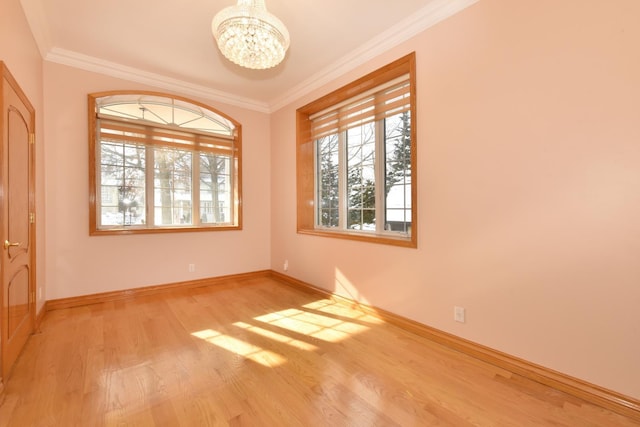 unfurnished room with crown molding, a chandelier, and light wood-type flooring