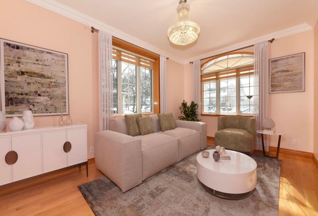 living area featuring crown molding, a notable chandelier, and light wood-type flooring