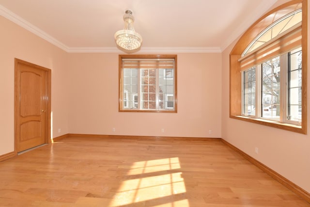 unfurnished room featuring crown molding, a chandelier, and light wood-type flooring