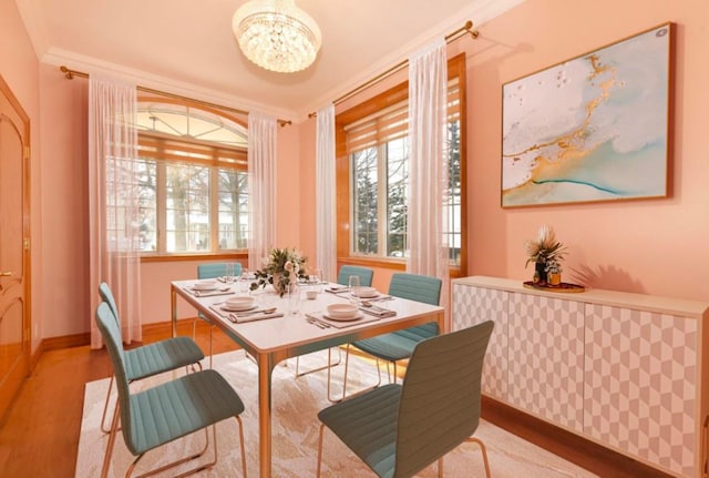 dining room featuring light hardwood / wood-style flooring, ornamental molding, and a chandelier