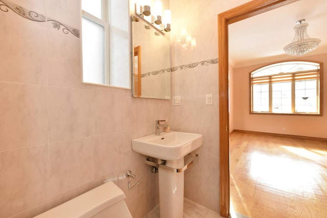 bathroom featuring tile walls and toilet