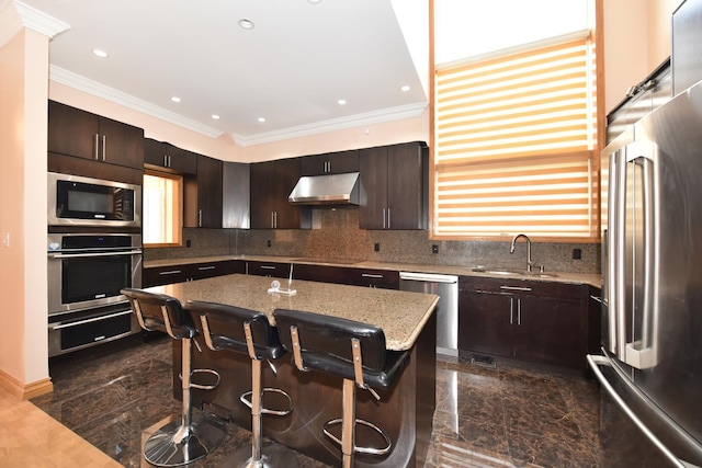 kitchen with sink, a breakfast bar area, dark brown cabinets, stainless steel appliances, and a center island