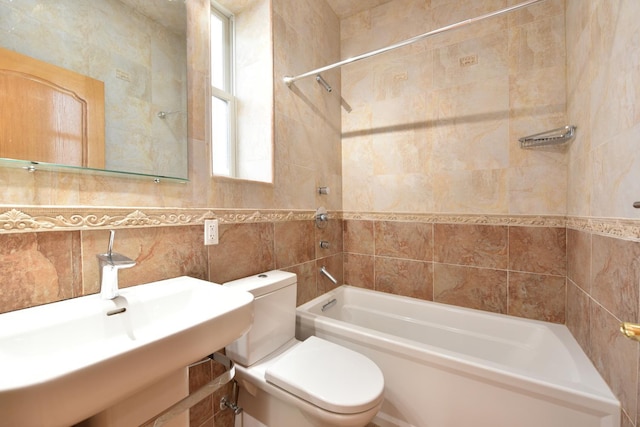 full bathroom with sink, tile walls, decorative backsplash, toilet, and tiled shower / bath