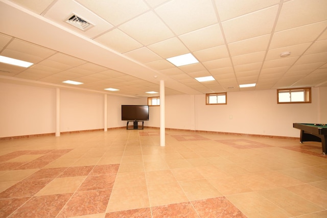 basement with a drop ceiling and plenty of natural light