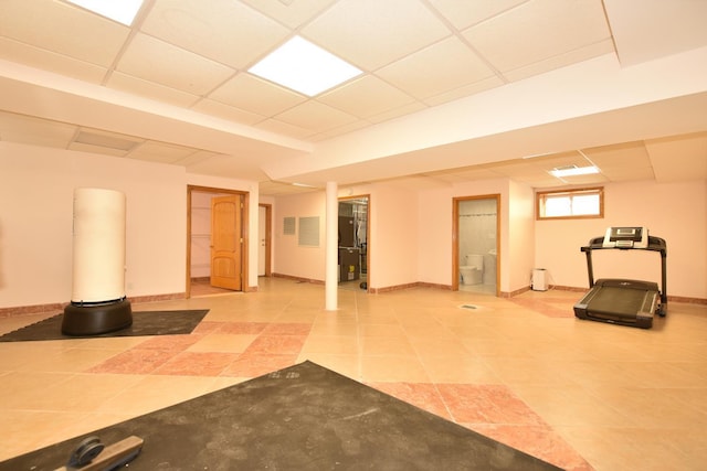 exercise room featuring a drop ceiling and tile patterned flooring