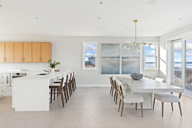 dining area featuring sink, a chandelier, and wine cooler