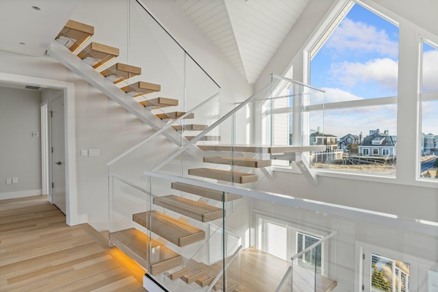 staircase with lofted ceiling and hardwood / wood-style floors