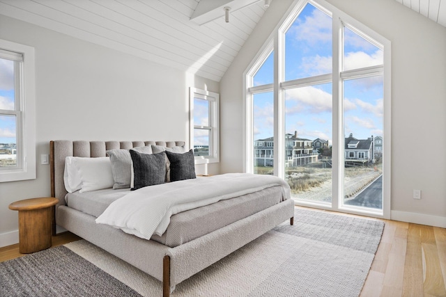 bedroom with wood ceiling, light wood-type flooring, and vaulted ceiling