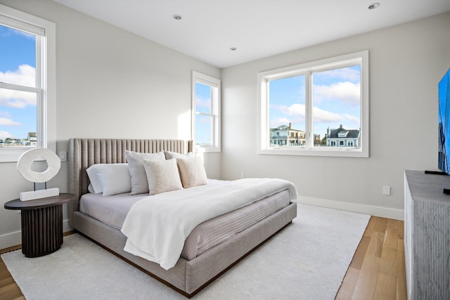 bedroom with hardwood / wood-style floors and multiple windows