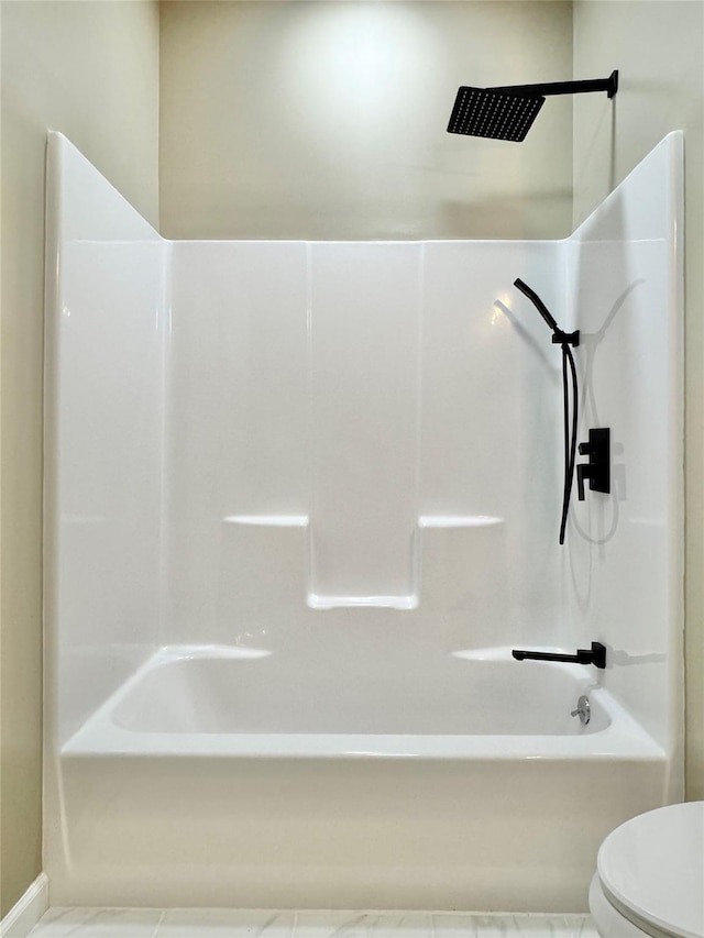 bathroom with toilet and bathing tub / shower combination