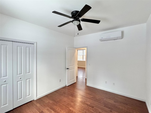 unfurnished bedroom with ceiling fan, a closet, dark hardwood / wood-style floors, and a wall unit AC