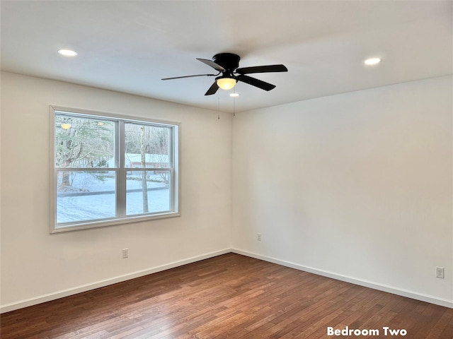 unfurnished room with ceiling fan and dark hardwood / wood-style flooring