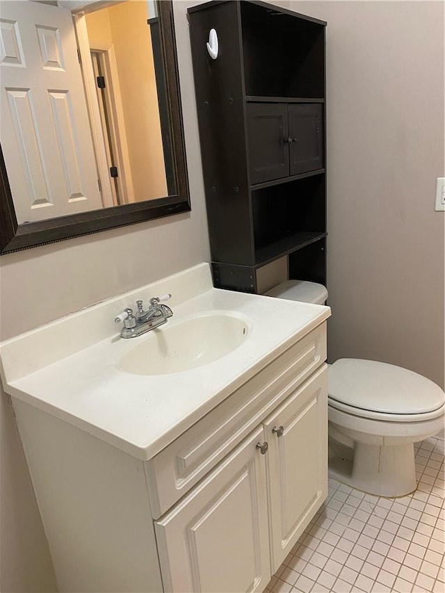 bathroom featuring vanity, tile patterned floors, and toilet