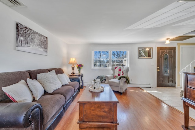 living room with light wood-style floors, visible vents, and baseboard heating