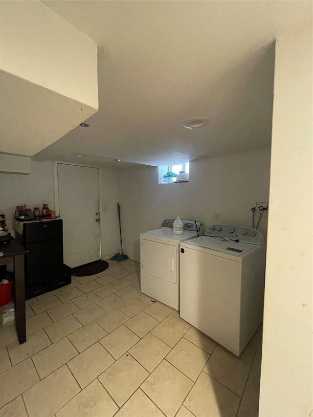 laundry area featuring laundry area, washer and clothes dryer, and light tile patterned floors