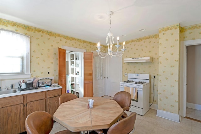 dining area featuring sink and a chandelier