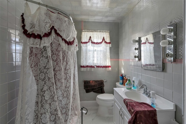 bathroom with vanity, toilet, tile walls, and curtained shower