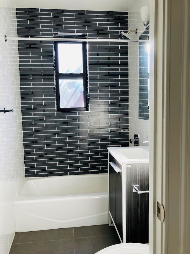 bathroom with tile walls, tile patterned flooring, vanity, and tiled shower / bath